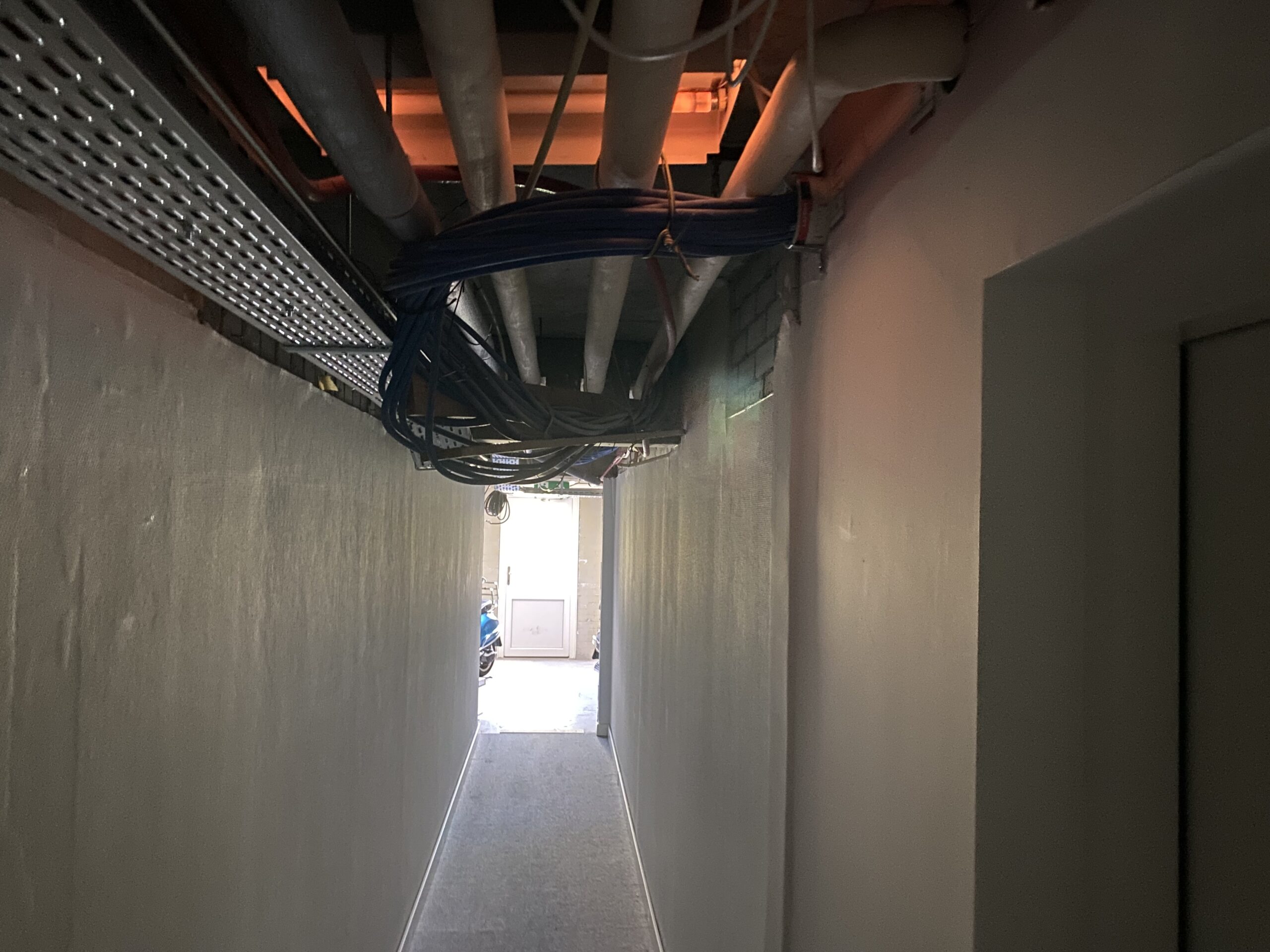 In de gang doet het licht het niet overal. Daarnaast is het plafond niet afgewerkt.