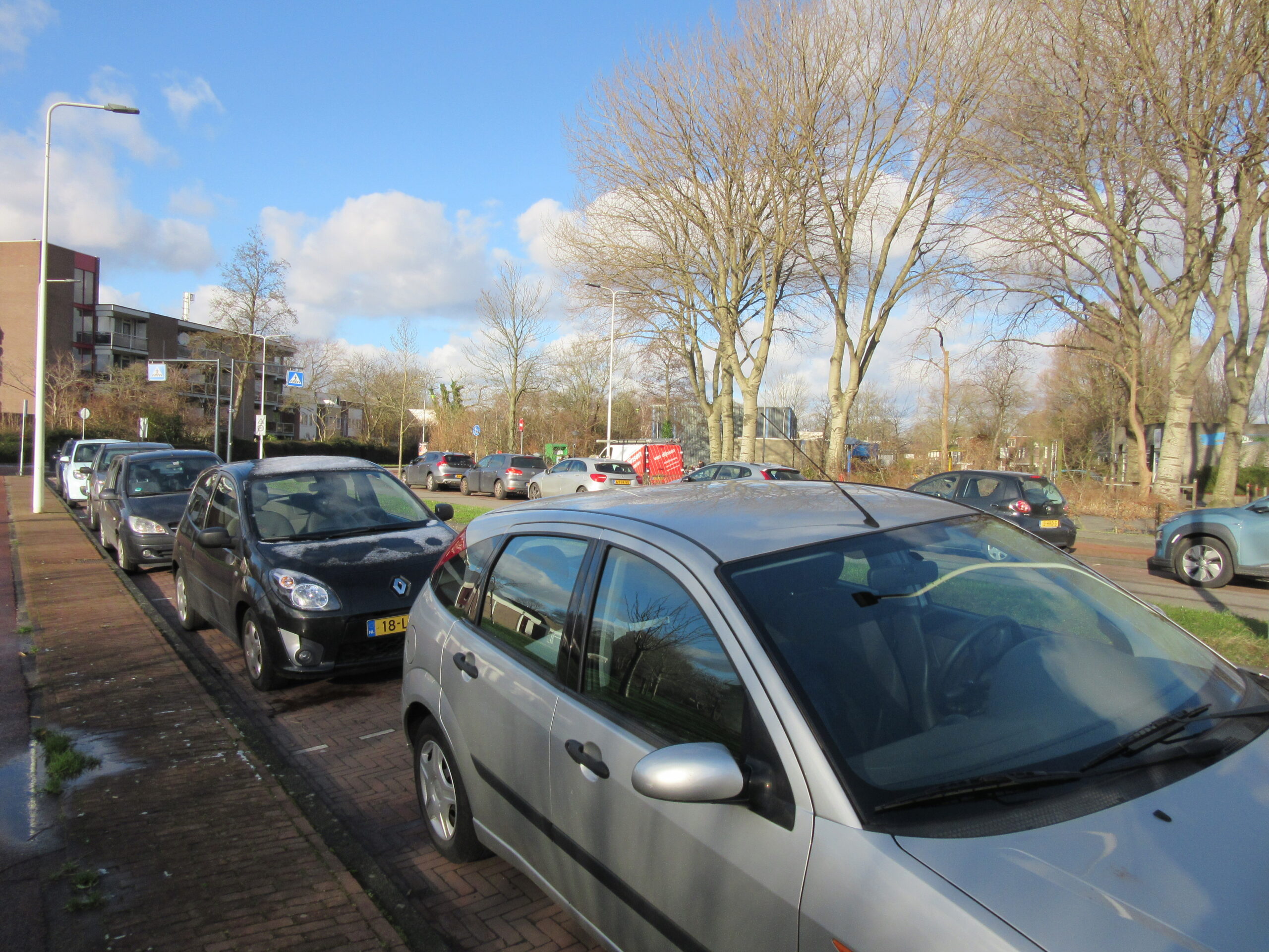 Tegenover de scholen verdwijnen volgens het plan parkeerplekken. (Foto: Louis Smit)