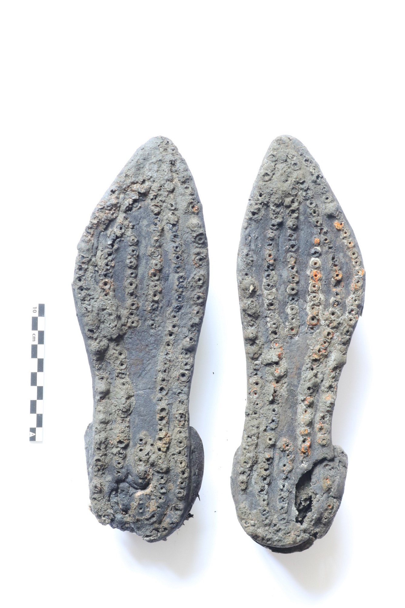 De schoenen vanaf de onderkant. Duidelijk is te zien dat het echt een paar bij elkaar horende schoenen betreft. Ook goed zichtbaar is de slijtage aan de hiel.