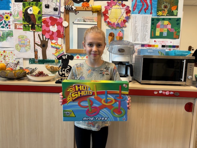 Dochter Katja laat de prijs zien die ze kreeg voor haar tekening voor Onafhankelijkheidsdag. (Foto: Louis Smit)