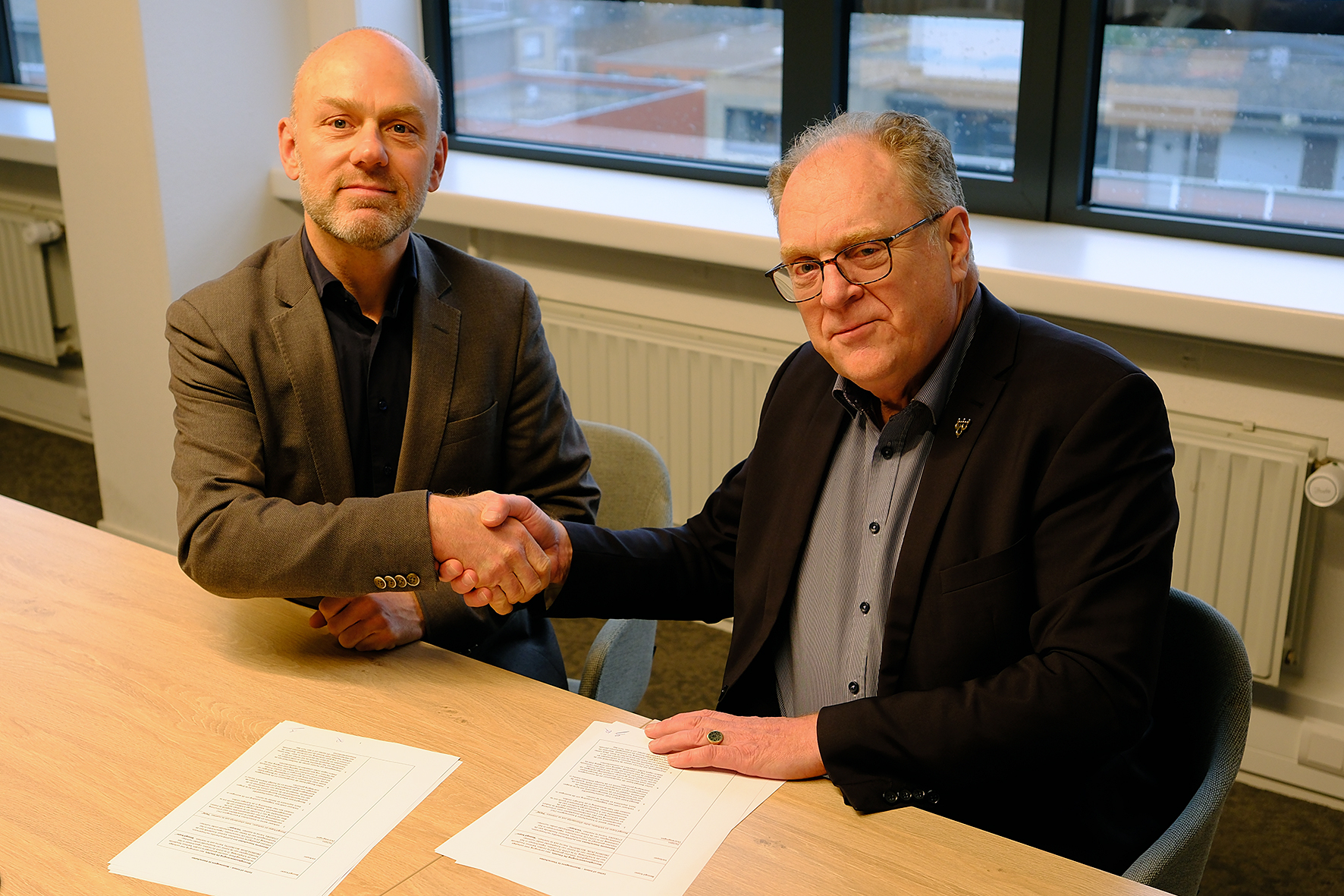Directeur Danny Wijnbelt van De Sleutels en wethouder Hans van der Elst (r) tekenen de intentieovereenkomst. (Foto: Gemeente Voorschoten)