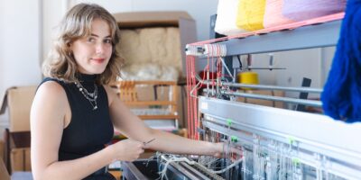 Vera van de Seyp bij het fietsweefgetouw van de Leidse Weverij in de werkplaats van Stichting Leidse Deken