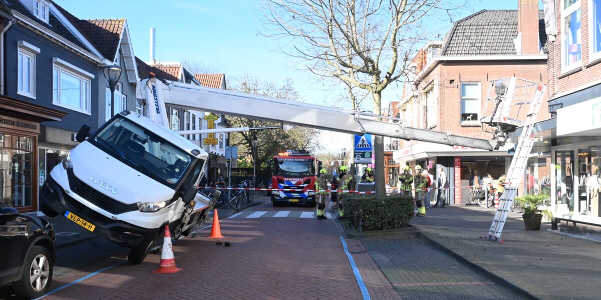 Hoogwerker kantelt tegen winkelpui