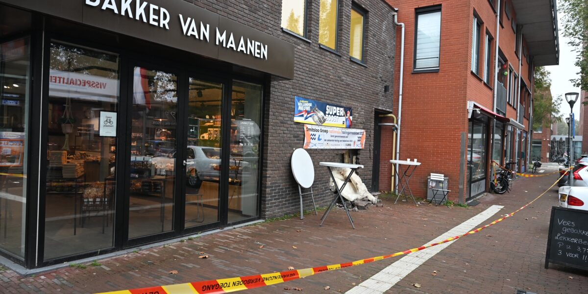 Auto rijdt achteruit door gevel van bakkerij in Leiden